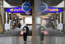 A pedestrian wears a face mask as the city operates under lockdown in response to an outbreak of the coronavirus disease (COVID-19) in Melbourne, Australia, Aug. 12, 2020. (AAP Image/James Ross via Reuters)
