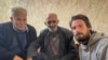 In this photo provided by the Syrian Emergency Task Force, American Travis Timmerman, right, sits with Mosaed al-Rifai, center, who found him in the Syrian desert, and the owner of the house where he took refuge, left, name not available, in Damascus, Syria, Dec. 12, 2024. 