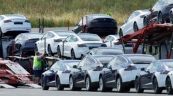 FILE - Tesla cars are loaded onto carriers at the Tesla electric car plant in Fremont, California, May 13, 2020. The Biden adminstration has made short-term emission reductions a top priority.