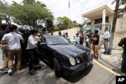 Media chases a car which came out from North Korean Embassy in Kuala Lumpur, Malaysia, Feb. 22, 2017.