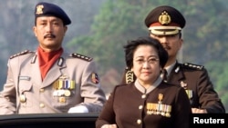 FILE - Indonesian President Megawati Sukarnoputri, flanked by her adjutant Colonel Budi Gunawan (R) and ceremony commander Police Commissioner Sunaryono (L) at the 56th anniversary of the country's police force in Jakarta, July 1, 2002.