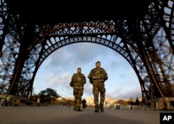 French soldiers patrol at the Eiffel Tower which remained closed on the first of three days of national mourning in Paris, Nov. 15, 2015.