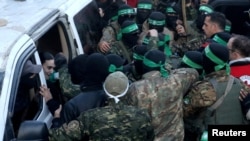 Боевики ХАМАС вокруг автомобиля, в котором в обмен на палестинских заключенных перевозят Эмили Дамари - заложницу, удерживаемую в Газе после смертоносного нападения 7 октября 2023 года, REUTERS/Dawoud Abu Alkas, 19 января 2025 года