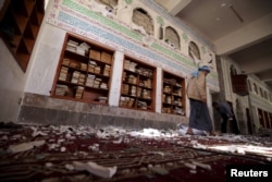 A Houthi militant walks inside the mosque after a suicide bomb attack in Sanaa, Yemen, March 20, 2015.