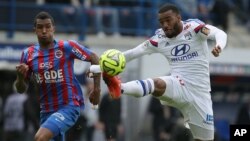 Alexandre Lacazette de Lyon, à droite, contrôle une balle de la tête, devançant Emmanuel Imorou de Caen, au cours d’un match de la ligue de France, remporté 3-0 par Caen, à Caen, dans l’Ouest de France, le 9 mai 2015. 