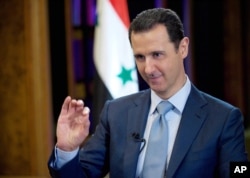 FILE - Syrian President Bashar Assad gives an interview with the BBC in Damascus, Syria. (Photo released by official Syrian news agency SANA)