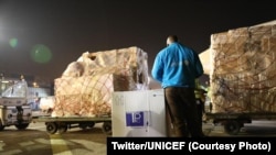Un employé de l'UNICEF surppectant l'envoi de vaccins COVID-19 d'AstraZeneca à l'aéroport international de N'Djili, Kinshasa, 3 mars 2021.