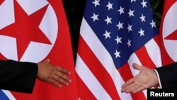 FILE - U.S. President Donald Trump and North Korea's leader Kim Jong Un meet at the start of their summit on the resort island of Sentosa, Singapore, June 12, 2018. 