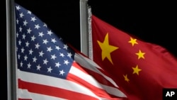 FILE - The American and Chinese flags wave ahead of the 2022 Winter Olympics, Feb. 2, 2022, in Zhangjiakou, China. 