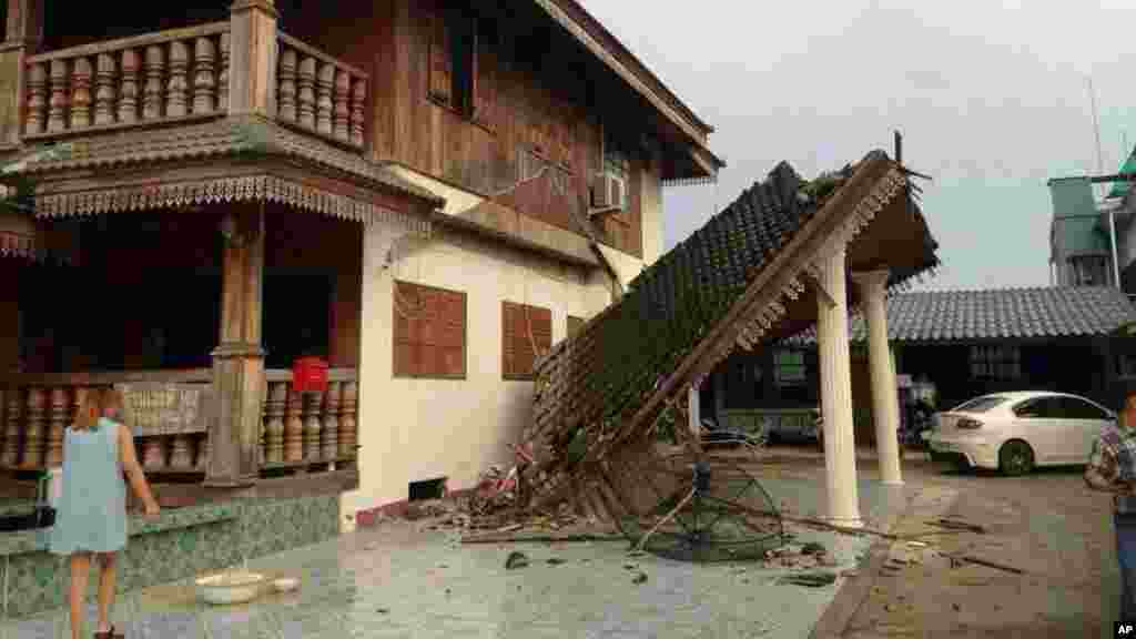 A woman looks at a damaged house following an earthquake in Chiang Rai, northern Thailand, May 5, 2014.