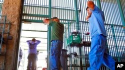 En esta fotografía del 9 de agosto de 2012 inmigrantes son transferidos fuera de un centro de detención en el sector de Tucson. Oficina de Aduanas y Protección Fronteriza de Estados Unidos en Tucson, Arizona. Foto AP.