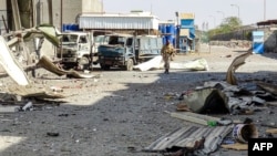 FILE - A member of the Yemeni pro-government forces walks through destruction in the outskirts of the port city of Hodeida, Nov. 18, 2018. Shi'ite rebels are accused of violating the U.N.-brokered cease-fire in Hodeida with a barrage of artillery and rockets.