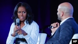 Former first lady Michelle Obama talks with Sam Kass, former White House chef and senior policy adviser for nutrition, at the Partnership for a Healthier America 2017 Healthier Future Summit in Washington, May 12, 2017