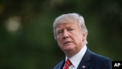 FILE - President Donald Trump walks from Marine One across the South Lawn of the White House in Washington, Aug. 23, 2017. 