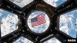 An American flag is visible in the windows of the cupola aboard the International Space Station. Thanks to a bill passed by Texas legislators in 1997 that put in place technical voting procedure for astronauts – nearly all of whom live in Texas – they hav