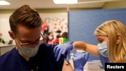 FILE PHOTO: Fourth-year medical student Anna Roesler administers the Pfizer-BioNTech coronavirus disease (COVID-19) vaccine at Indiana University Health, Methodist Hospital in Indianapolis, Indiana, U.S., December 16, 2020. REUTERS/Bryan Woolston/File Pho