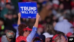 A supporter arrives before Republican presidential candidate former President Donald Trump speaks at a campaign rally, in Reading, Pennsylvania, Nov. 4, 2024.