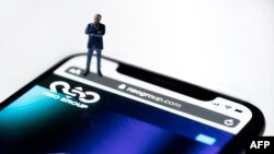 Picha yenye simu inayoonyesha tovuti ya shirika la NSO la Israeli ikiwa na programu ya 'Pegasus' ya udukuzi, kwenye maonyesho Paris on Julai 21, 2021.(Photo by JOEL SAGET / AFP)