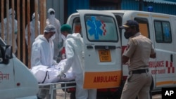 រូបឯកសារ៖ បុគ្គលិកសុខាភិបាលឥណ្ឌាកំពុងលើកសាកសពអ្នកជំងឺកូវីដ១៩ ដាក់ក្នុងរថយន្តនៅមុខមន្ទីរពេទ្យបណ្តោះអាសន្នមួយ នៅទីក្រុងម៉ុមបៃ ប្រទេសឥណ្ឌា កាលពីថ្ងៃទី ៤ ខែឧសភា ឆ្នាំ ២០២១។