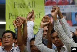 FILE - Members of the opposition Cambodia National Rescue Party raise joined hands for photographs at their party headquarters in Phnom Penh, May 27, 2016.