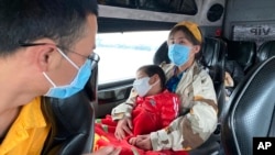 People wear masks on a bus in Quang Ninh province, Vietnam, Jan. 28, 2018. A tourism company director in Vietnam says the coronavirus outbreak that began in China has hit his industry “very hard, like a giant bomb."