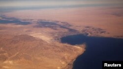 FILE - The Suez Canal connecting the Mediterranean Sea to the Red Sea is pictured from the window of a commercial plane flying over Egypt.