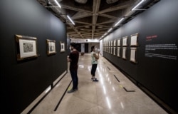 Personas con mascarillas observan grabados en metal de la colección Suite Vollard del artista español Pablo Picasso durante una exposición en el Museo del Banco Central, en San José, Costa Rica, el 10 de junio de 2020.
