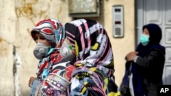 Mujeres iraníes en el centro de Teherán usan máscaras para protegerse del coronavirus, el domingo 23 de febrero de 2020.