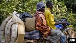 FILE - An Ivorian refugee gets a lift on motor bike taxi toward Zwedru, Liberia, March 24, 2011.