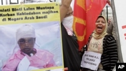 Para tenaga kerja Indonesia meneriakkan slogan-slogan dalam demonstrasi di luar gedung DPR/MPR, memprotes penyiksaan seorang tenaga kerja Indonesia di Arab Saudi, Jakarta, 23 November 2010.