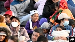 Solicitantes de asilo esperan entre dos muros fronterizos sobre territorio estadounidense a lo largo de la frontera con México, cerca de Tijuana, el lunes 8 de mayo de 2023, en San Diego. Los migrantes aguardan a ser procesados por la Patrulla Fronteriza.