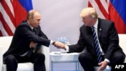 Les présidents russe Vladimir Poutine (g) et américain Donald Trump, le 7 juillet 2017 à Hambourg, lors du sommet du G20 ( AFP/Archives / SAUL LOEB )