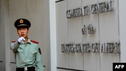 (FILES) This file photo taken on September 18, 2012 shows a Chinese paramilitary policeman gesturing to photographers at the entrance to the US consulate in Chengdu, southwest China's Sichuan province. - China said on July 24, 2020 it had revoked…