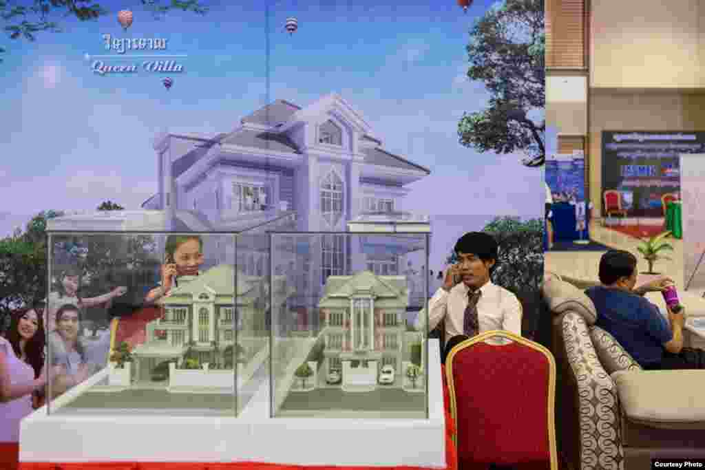 ៣០ មិនា ២០១៤ ភ្នំពេញ កម្ពុជា៖ ពាណិជ្ជករ​និយាយ​ទូរស័ព្ទ​ក្នុង​អំឡុង​​ការ​តាំង​ពិព័រណ៍​មួយ​នៅ​កោះពេជ្រ។ ក្រុង​រណប​​ជា​ច្រើន​​ត្រូវ​បាន​គេ​​សាងសង់​នៅ​ជុំវិញ​រាជធានី​ភ្នំពេញ ហើយ​ផ្តល់​ឲ្យ​នូវ​ផ្ទះ​មាន​គំរូ​ដូចៗ​គ្នា​នៅ​ក្នុង​តំបន់​លំនៅដ្ឋាន​ធំៗ។&nbsp;​&nbsp;&copy; Nicolas Axelrod / Ruom