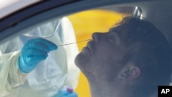 Seorang petugas medis melakukan tes Covid-19 terhadap seorang pengunjung di Christchurch, Selandia Baru, 13 Agustus 2020 