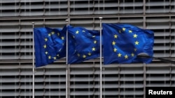 FILE - European Union flags flutter outside the EU Commission headquarters in Brussels, Belgium, May 5, 2021. 