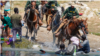 ARCHIVO - Inmigrantes haitianos son impedidos de cruzar hacia la parte estadounidense en Del Río, Texas, en septiembre de 2021.