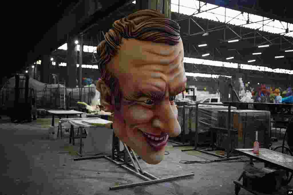A carnival float figure of France's President Emmanuel Macron sits at a warehouse in Nice, southern France, as a celebration of nature, human connection and life itself after months of lockdowns, social distancing and banned public gatherings kicks off.