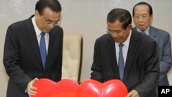 លោកLi Keqiang នាយក​រដ្ឋ​មន្ត្រី​ចិន (ឆ្វេង) ទាញ​រូប​បេះដូង​ដែល​តំណាង​ឲ្យ​ដំណើរ​នៃ​ក្តីស្រឡាញ់​ពី​បេះដូង​រវាង​កម្ពុជា និង​ចិន ជាមួយ​សមភាគី​របស់​លោក គឺ​នាយក​រដ្ឋមន្រ្តី​ខ្មែរ លោក ហ៊ុន សែន (កណ្តាល) ក្នុង​អំឡុង​ពិធី​ចុះ​ហត្ថលេខា​នៅ​វិមាន​សន្តិភាព​ក្នុង​រាជធានី​ភ្នំពេញ នៅថ្ងៃទី ១១ ខែមករា ឆ្នាំ២០១៨។