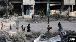 Palestinezët kalojnë përkrah rrënojave një ditë pas sulmit të ushtrisë izraelite që liroi katër pengje (9 qershor 2024).