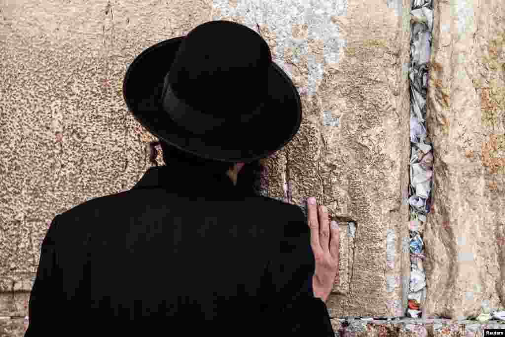 A man prays as notes to God were placed in the cracks of the Western Wall, Judaism's holiest prayer site, to make space for new notes ahead of the Jewish New Year, in Jerusalem's Old City.