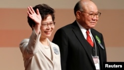 លោកស្រី Carrie Lam បក់​ដៃ​ បន្ទាប់​ពី​លោក​ស្រី​ទទួល​បាន​ជ័យជម្នះ​ក្នុង​តំណែង​ជា​ប្រធាន​ប្រតិបត្តិ​បន្ទាប់​របស់​ក្រុង​ហុងកុង នៅ​ពេល​ដែល​លោក Woo Kwok-hing ឈរ​នៅ​ក្បែរ​លោក​ស្រី​ នៅ​ក្នុង​ក្រុង​ហុងកុង កាលពី​ថ្ងៃទី២៦ ខែមីនា ឆ្នាំ២០១៧។