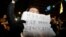 A person holds a placard that reads "Democracy will not surrender to Yoon Suk Yeol" as people gather outside the National Assembly, after South Korean President Yoon Suk Yeol declared martial law, in Seoul, South Korea, Dec. 4, 2024. 