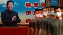 FILE - Paramilitary police officers march in formation near a poster of Chinese President Xi Jinping at the gate to the Forbidden City, in Beijing, China, May 22, 2020.