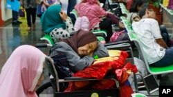 A patient takes a nap on her wheelchair as she waits with others at the registration desk at Dharmais Cancer Hospital in Jakarta, Indonesia, Monday, May 15, 2017 as the hospital's information system is in trouble by cyberattack.