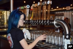 Maya Martinez, a manager at the Rio Bravo Brewing Company in Albuquerque, N.M., pours a craft beer, May 3, 2017, just days before the brewery was set to unveil a new beer on Cinco de Mayo.