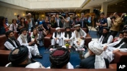 FILE - In this file photo taken on Tuesday, May 28, 2019, Mullah Abdul Ghani Baradar, the Taliban's top political leader, left, Sher Mohammad Abbas Stanikzai, the Taliban's chief negotiator, second left, and other members of the Taliban's group speak to reporters.
