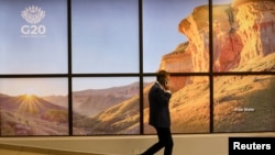 Un invitado pasa por una pantalla con el logotipo del G20, antes de una reunión de los ministros de Asuntos Exteriores del G20 organizada por Sudáfrica, bajo el tema "Solidaridad, Igualdad y Sostenibilidad", en Johannesburgo, Sudáfrica, el 20 de febrero de 2025. REUTERS