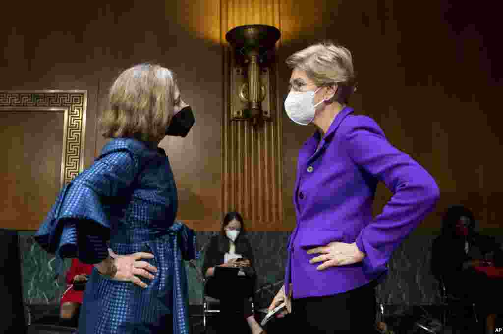Sen. Elizabeth Warren, D-Mass., right, talks with Sarah Bloom Raskin, a nominee to be the Federal Reserve's Board of Governors vice chair for supervision, the nation's top bank regulator, before a Senate Banking, Housing and Urban Affairs Committee confirmation hearing on in Washington.