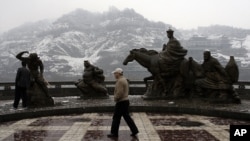 A visitor walks past the statues of the characters from the Chinese novel 'Journey to the West' Thursday March 15, 2007 in Lanzhou, China. Lanzhou was an important town along with the ancient Silk Road connecting China and Europe.